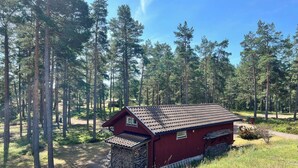 A red wooden cabin surrounded by a forest. - Room-archipelago Cottage is Utö (Uto)