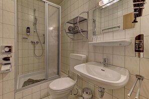 A bathroom with a glass-enclosed shower, a toilet, a sink, and a towel rack. - Hotel Haus Anna (Bayerisch Eisenstein)