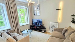 A modern living room with a sofa set, a TV, and a coffee table. - Riga Stylish Old Town getaway next to Dome square (Rīga)