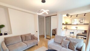 A modern living room with two sofas, a coffee table, and a kitchen area in the background. - Riga Stylish Old Town getaway next to Dome square (Rīga)