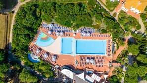 Vue aérienne d’un complexe hôtelier doté de plusieurs piscines, de chaises longues et d’un vaste espace paysager.