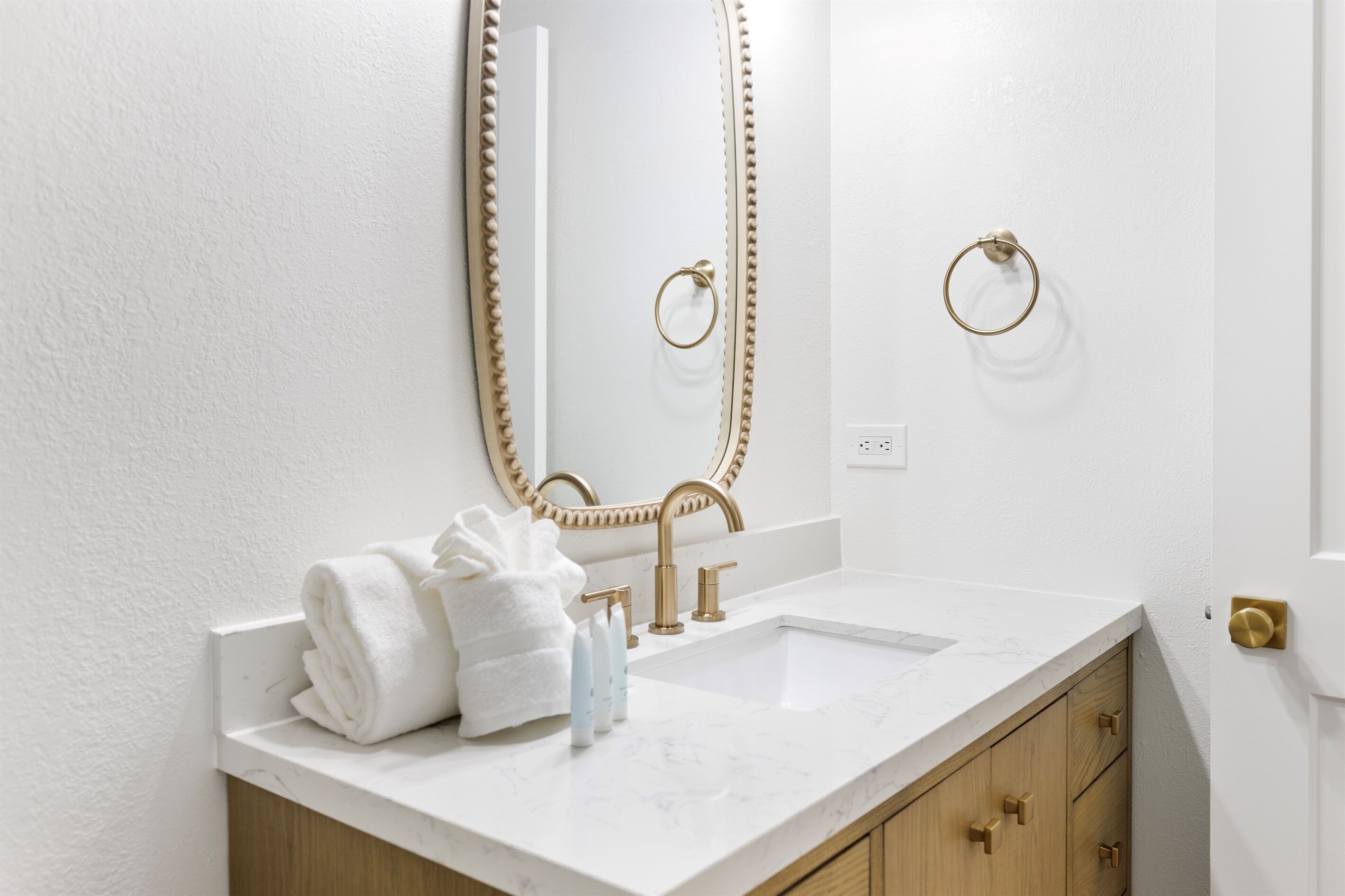 Your elegant vanity features marble countertops, gold fixtures, and plush towels—perfect for your morning routine in this luxurious bathroom.