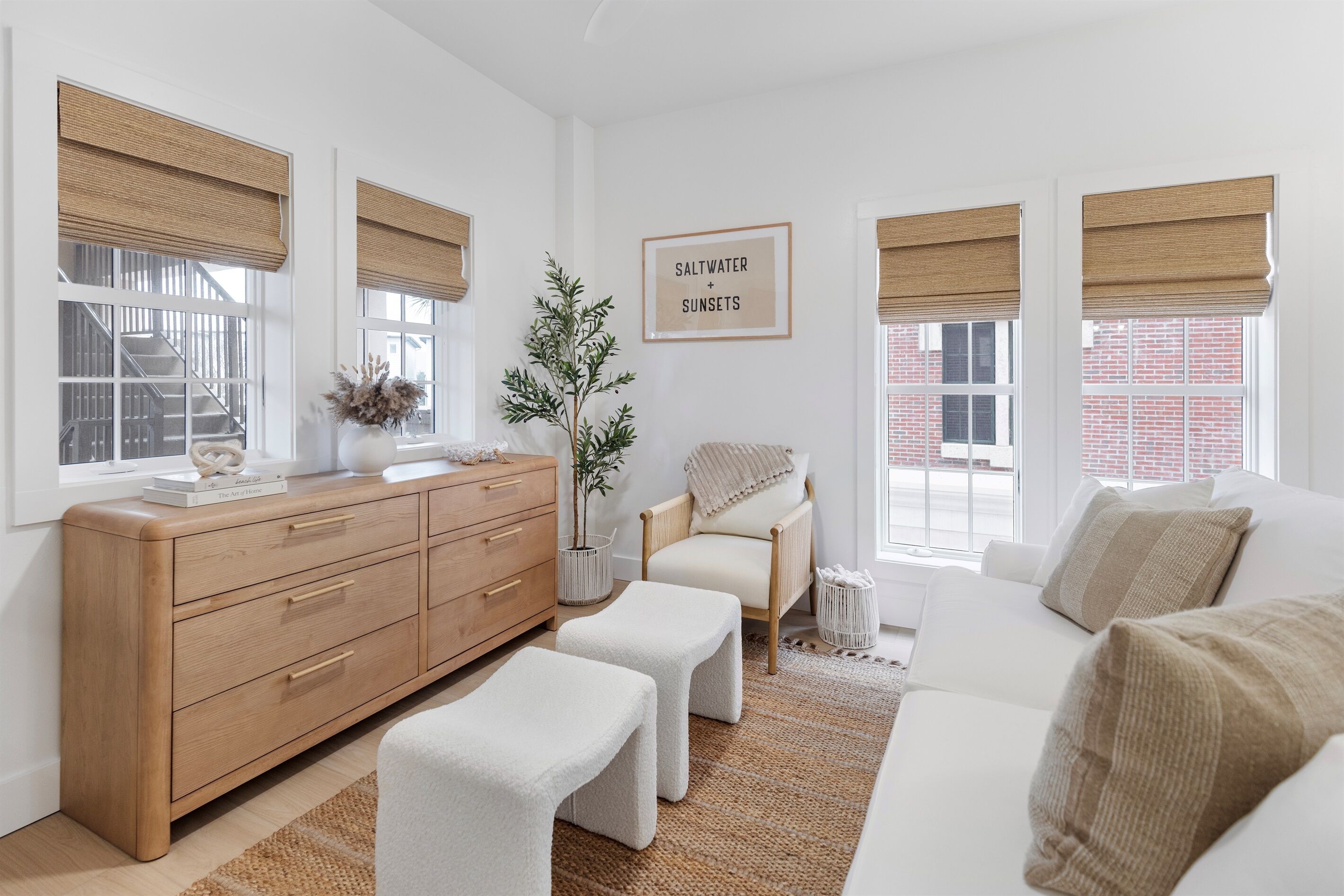 Sink into this serene living space where warm wood tones and soft textures create your perfect retreat for relaxation.
