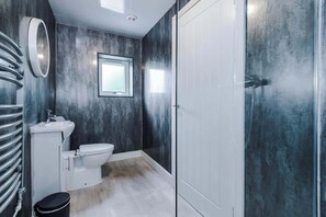 Un baño con inodoro, lavamanos y espejo.