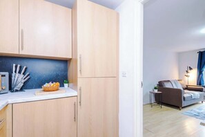 Eine moderne Küche mit Holzausbau, einer Arbeitsplatte mit Schneidebrett und einer Schüssel mit Snacks.