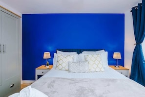 Ein Schlafzimmer mit einem großen Bett, zwei Nachttischen und einem Kleiderschrank.