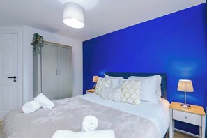 A hotel room with a bed, two bedside tables, a wardrobe, and a door. - Stylish Allure 2BR | City Centre| Manchester Event (Greater Manchester)