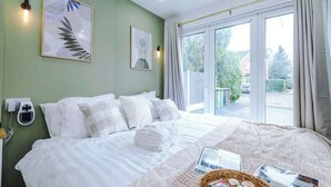 A hotel room with a bed, a bedside scale, a window with curtains, and a wall-mounted light fixture. - NEW! Preston Central & Sleek Studio | Wifi Parking (Fulwood)