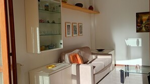 Un salon moderne avec un canapé, une table basse en verre et un meuble avec des portes en verre.