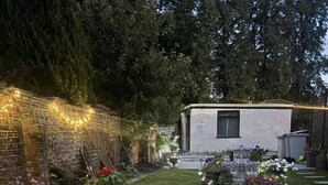 A well-maintained patio area with a tiled floor, surrounded by lush greenery and decorative lighting. - Wonky 2 A Cosy Hideaway in the Heart of Cheshire (Macclesfield)