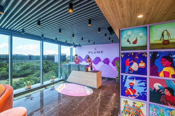 A modern reception area with a city view, a reception desk, and colorful artwork on the wall.