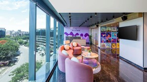 Una moderna zona de recepción con vistas a la ciudad, un mostrador de recepción y coloridas obras de arte en la pared.