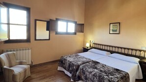 A bedroom with a double bed, a chair, a radiator, and a window. - House for 8 Bufones de Pría (Pria)