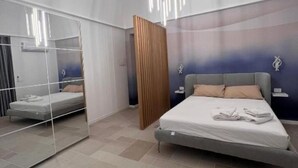 Un dormitorio moderno con cama, un espejo grande y un panel de madera.