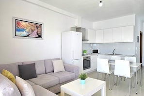 A modern apartment with a living area, kitchenette, and dining space. - Panorama View Apartment In Saranda - 271 (Sarandë)