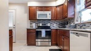 A kitchen with wooden cabinets, a stainless steel microwave, oven, and dishwasher. - 5 Woods Dr (Mechanicsburg)