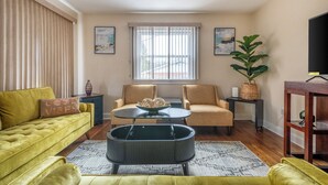 A living room with a yellow sofa, two armchairs, a coffee table, and a large window with blinds. - 5 Woods Dr (Mechanicsburg)