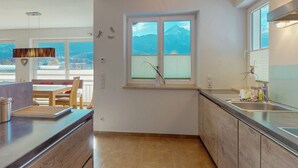 Uma cozinha moderna com uma janela grande, armários de madeira e uma pia embutida.