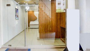 Ein modernes Interieur mit Glastür, einer Holzwand und einer Treppe, die in eine obere Etage führt.