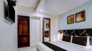 Ein Hotelzimmer mit einem Bett, einem Kleiderschrank, einem Spiegel und zwei Bildern an der Wand.