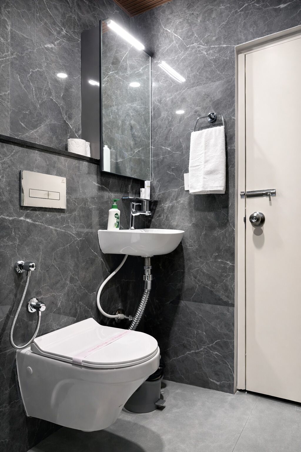 Uma casa de banho moderna com sanita, lavatório e chuveiro.
