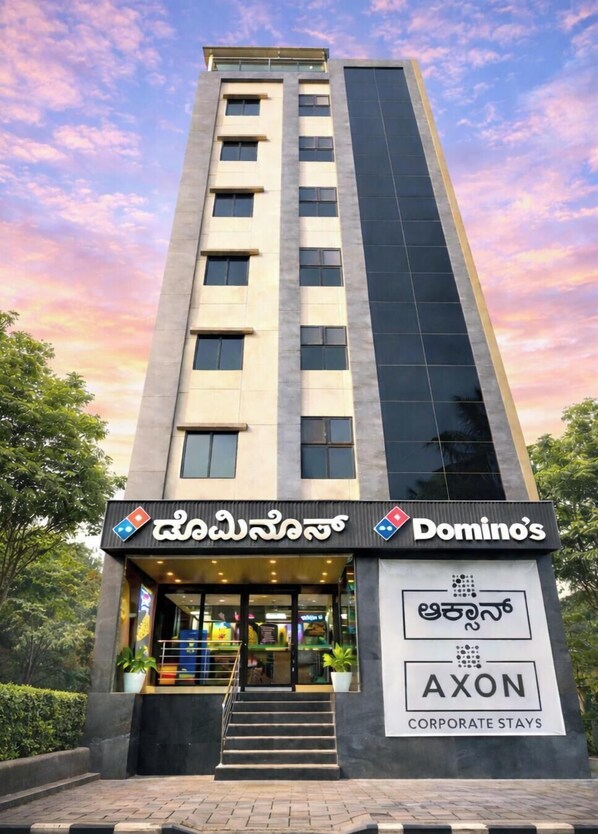 A tall building with a Domino's Pizza sign and an AXON corporate stays sign. - Axon Corporate Stays Whitefield Bengaluru (Bengaluru)
