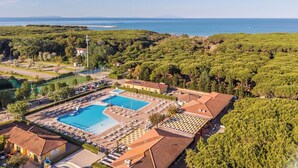 Ein Resort mit Swimmingpool, Liegestühlen und Meerblick.