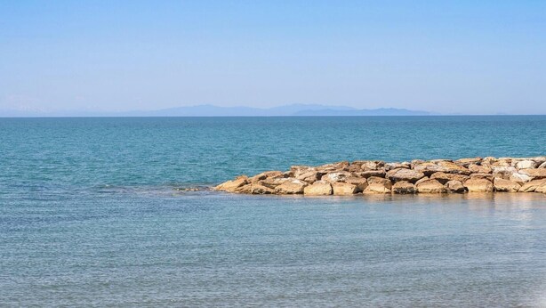Eine Küstenlandschaft mit felsiger Küste und ruhigem Meer.