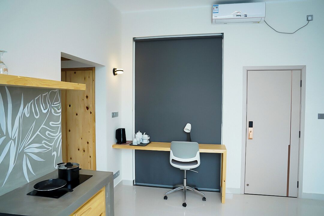 A modern kitchen with a built-in stove, a wooden countertop, and a grey chair.