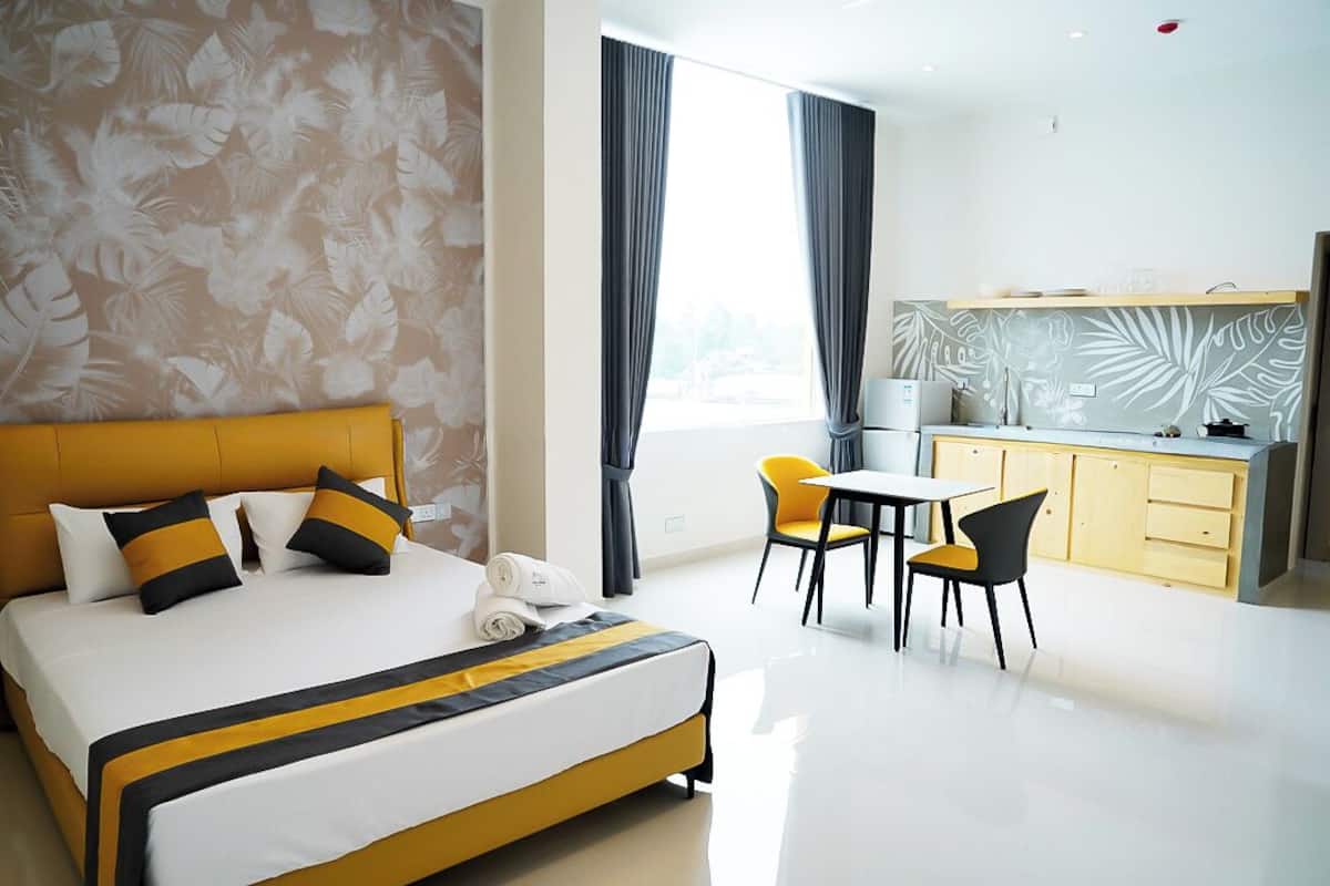 A hotel room with a bed, a small dining area, and a kitchen.