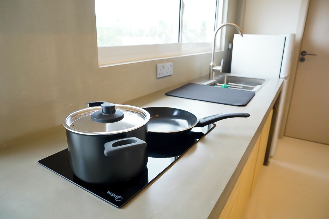 A modern kitchen with an induction cooktop, a pot, and a frying pan.