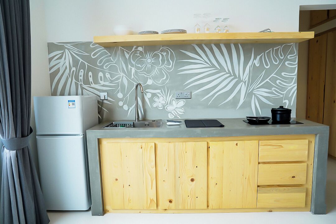 A compact kitchenette with a refrigerator, a sink, and a countertop.