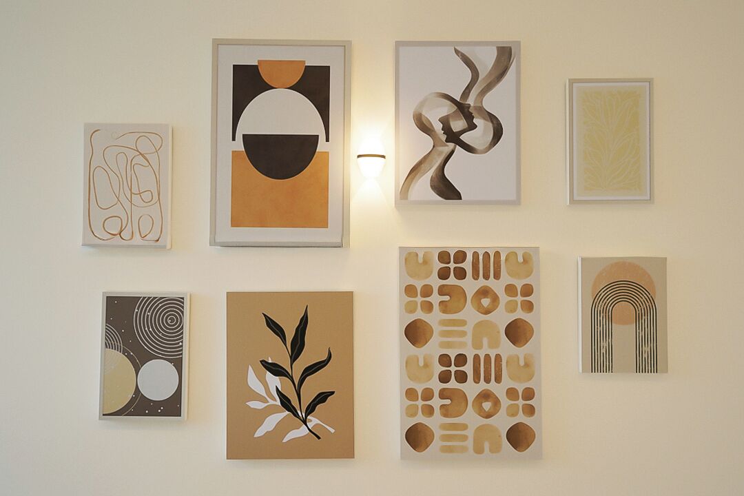 Una pared galería con diversas obras de arte abstracto.