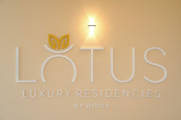 Logotipo de 'LUTUS Luxury Residencies by Wings' con una flor de loto estilizada y una lámpara.