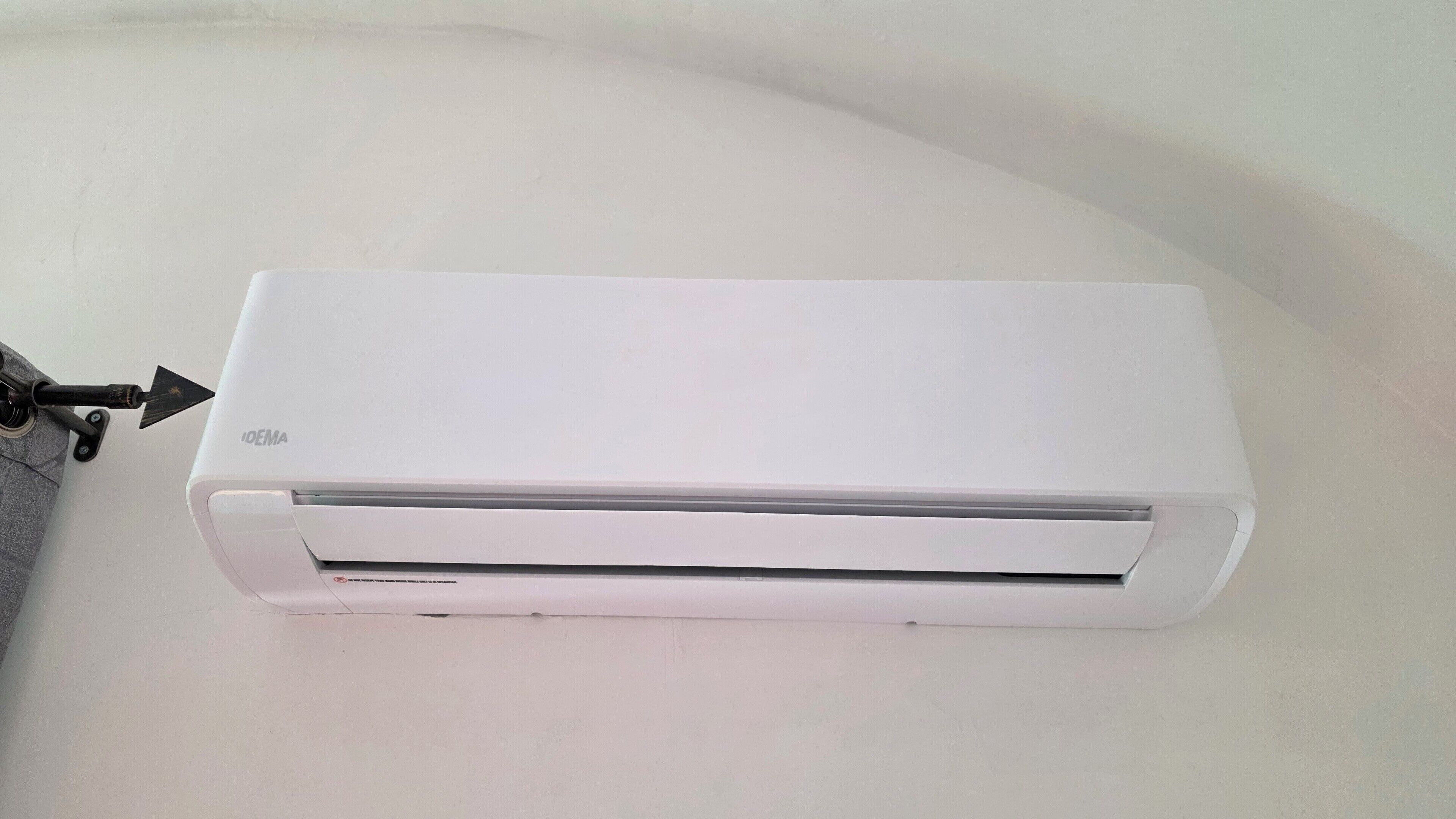 A white air conditioning unit mounted on a wall.