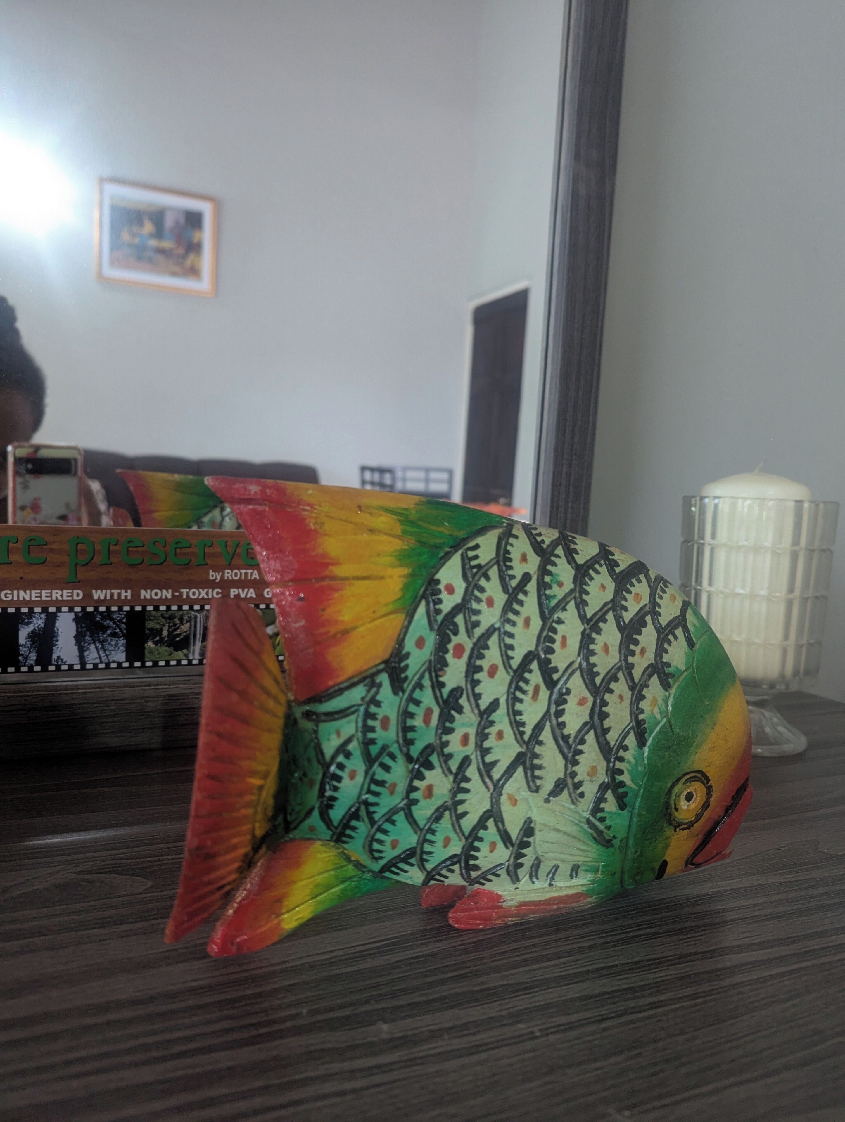 A colorful fish-shaped object on a wooden surface.