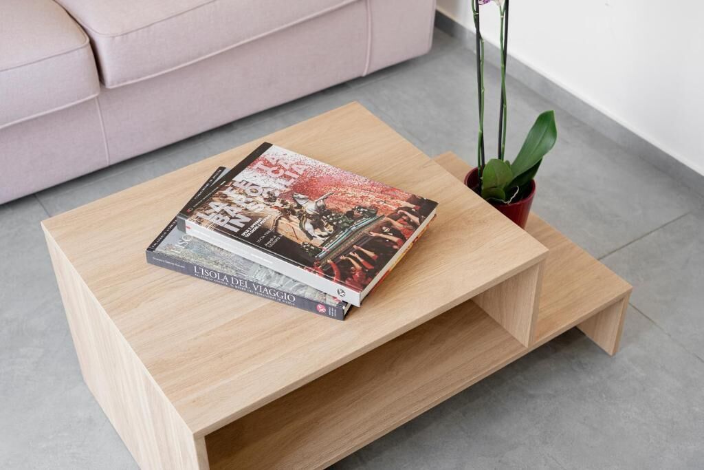 Ein Holztisch mit zwei Büchern und einer Topfpflanze.