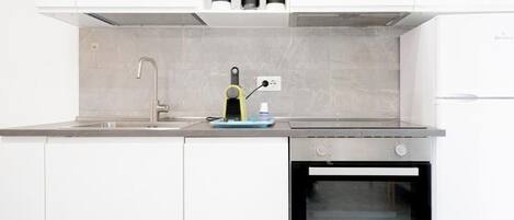 A modern kitchen with a built-in oven, a sink, and a coffee machine.