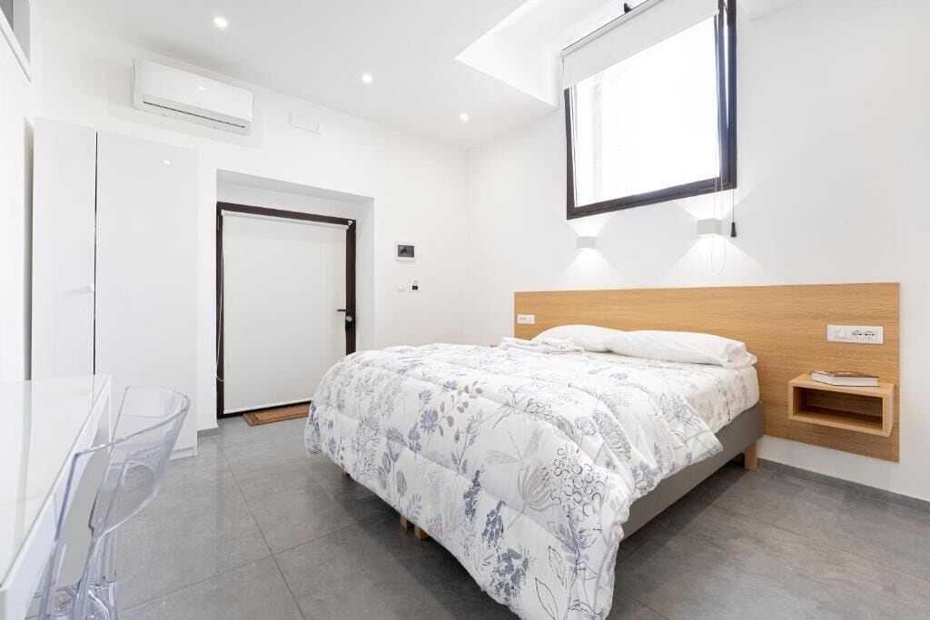 A modern bedroom with a bed, a desk, and a chair.