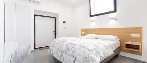 A modern bedroom with a bed, a desk, and a chair.