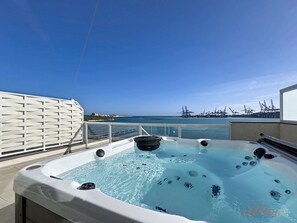 A hot tub on a balcony with a clear view of the sea and port cranes. - South 32 Hotel by Zzzing (Birzebbuga)