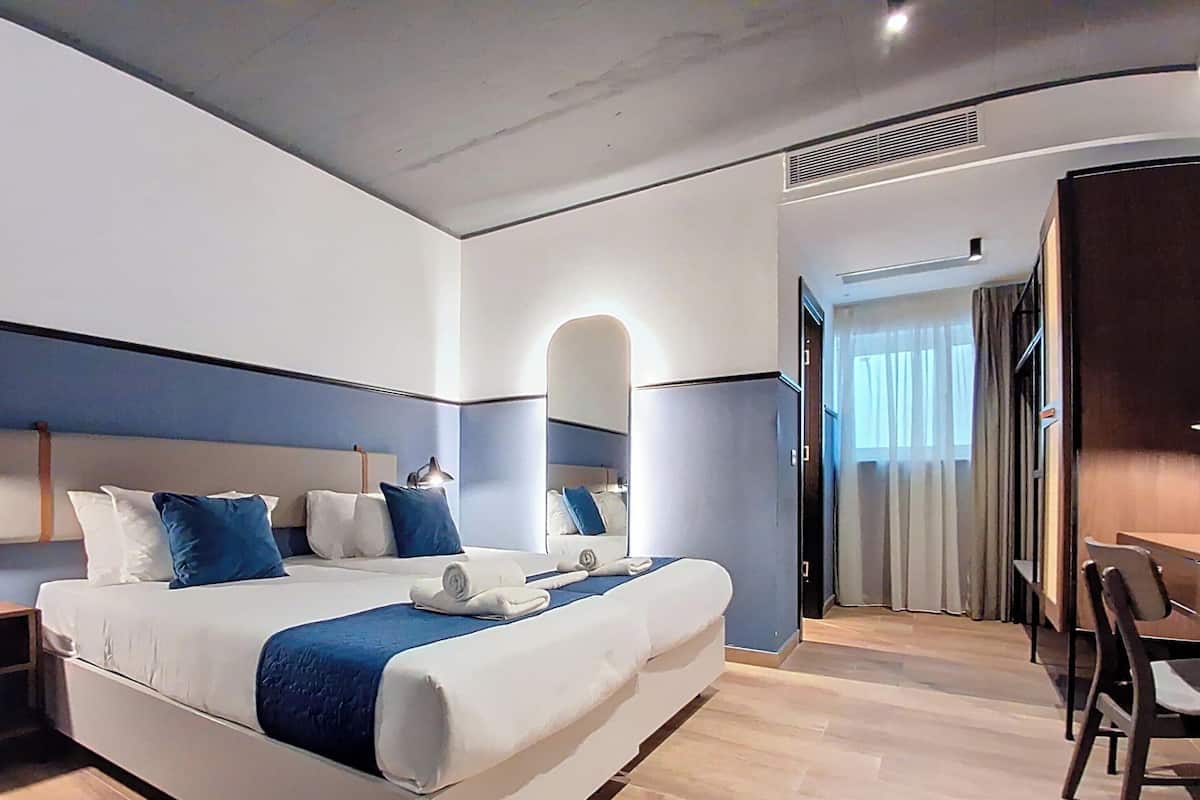 Een moderne hotelkamer met een groot bed, een bureau en een stoel.