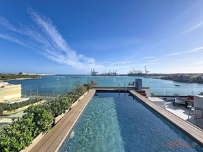 A rooftop infinity pool with a clear view of the sea and port in the background. - South 32 Hotel by Zzzing (Birzebbuga)