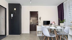 Une cuisine moderne avec des meubles de couleur sombre et un plan de travail blanc.