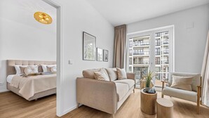 Un salon moderne avec un canapé, un fauteuil et une table basse ronde en bois.