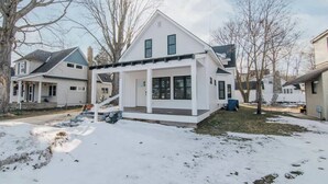 A single-story house with a front porch and a covered entryway. - High Tide: Harbor View: Walk2town/Beach: sleeps 12 (Boyne City)