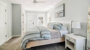 A bedroom with a bed, nightstand, and ceiling fan. - High Tide: Harbor View: Walk2town/Beach: sleeps 12 (Boyne City)
