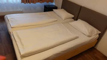 A double bed with two pillows and a wooden headboard in a hotel room.