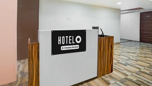 A hotel reception desk with a sign that reads "HOTELO Company Serviced." - Super Hotel O Dindoli Surat (Surat)