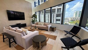 A modern living room with a sofa, coffee table, and a black chair. - Downtown Miami 1BR Walk to Bayside Kaseya Gym Pool (Miami)
